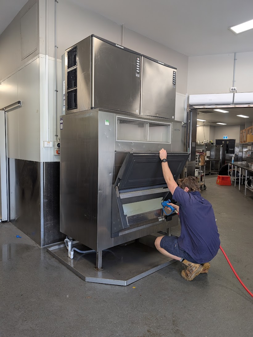 CHEFTECH technician cleaning and servicing a Scotsman commercial ice machine and bin